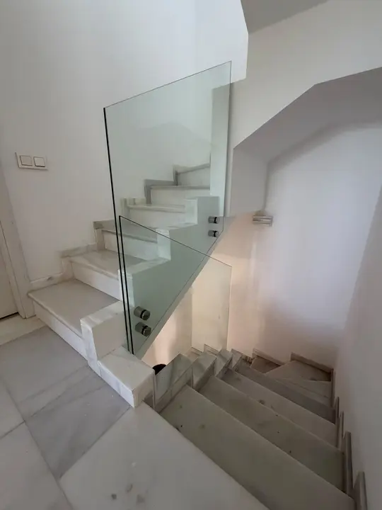 Glass balustrade on a white marble staircase