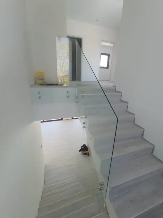 Glass balustrade on a white indoor staircase