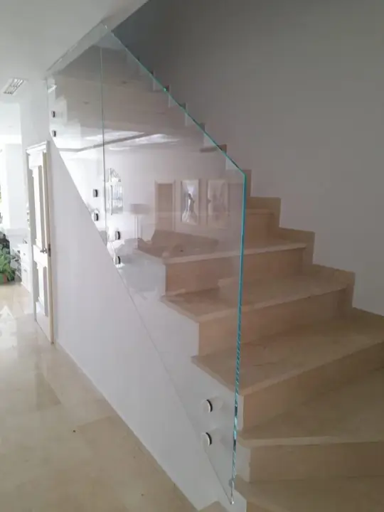 Clamp-fixed glass balustrade on a marble staircase