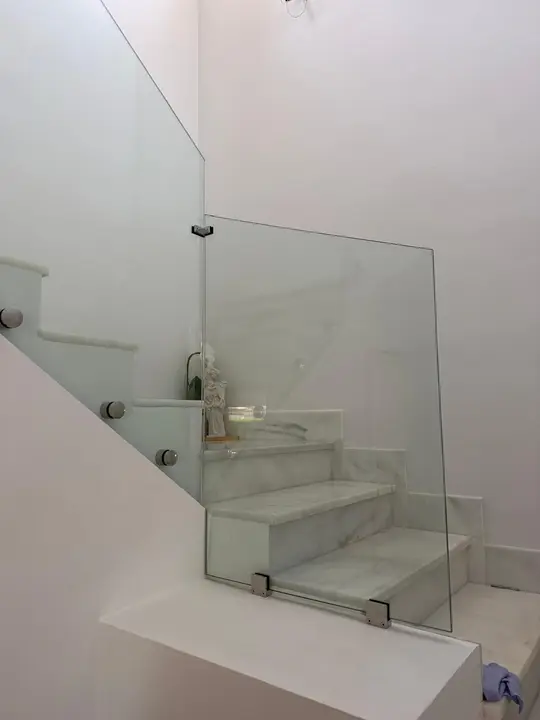 Clamp-fixed glass balustrade on a stair landing