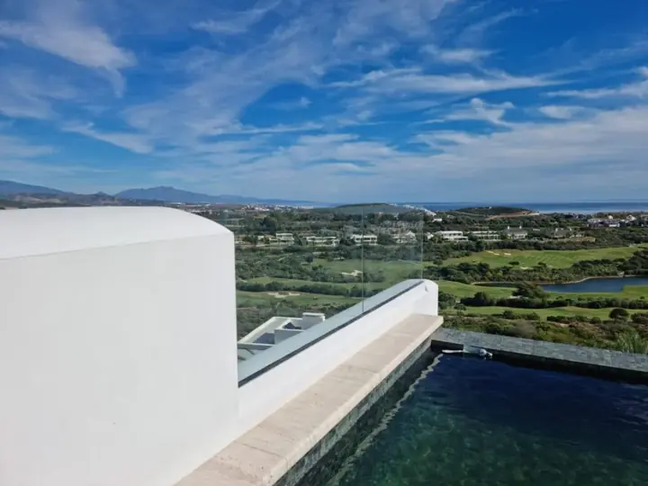 Glass balustrade on a pool terrace with golf views