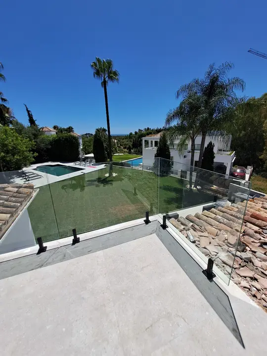 Clamp-fixed glass balustrade on a pool terrace