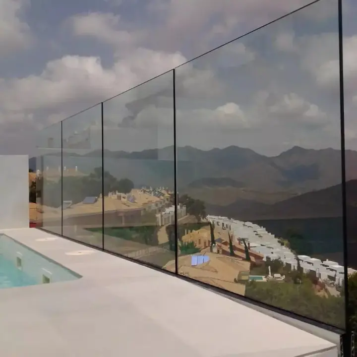 Frameless glass balustrade on a pool terrace with mountain views