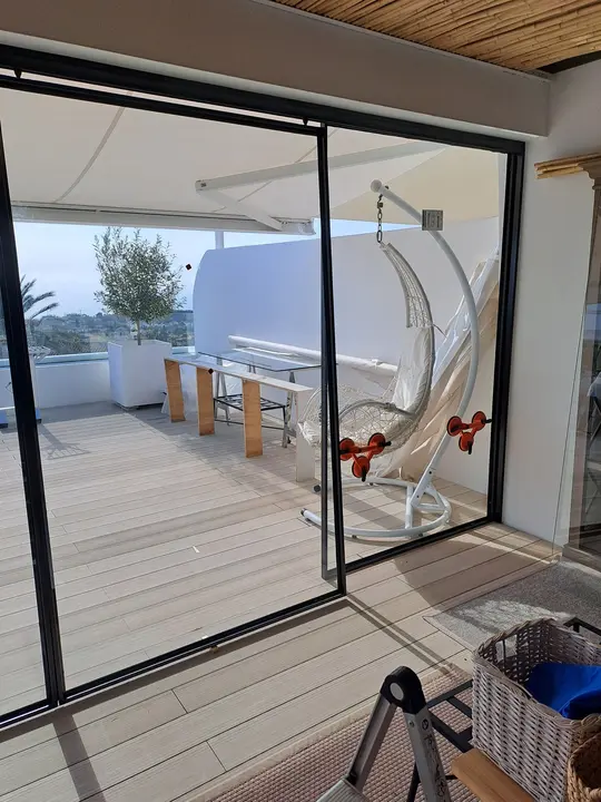 Sliding glass door with a black profile onto the terrace