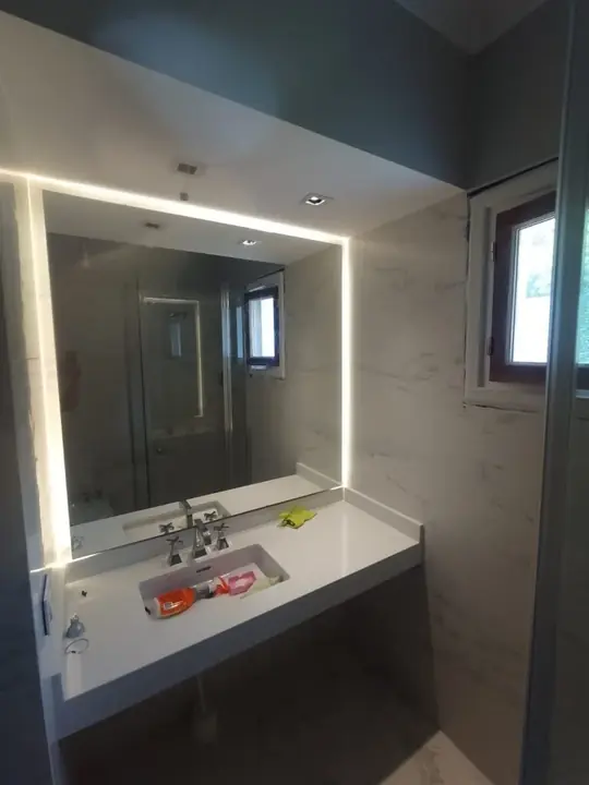 Mirror with LED lighting above a wall-hung washbasin