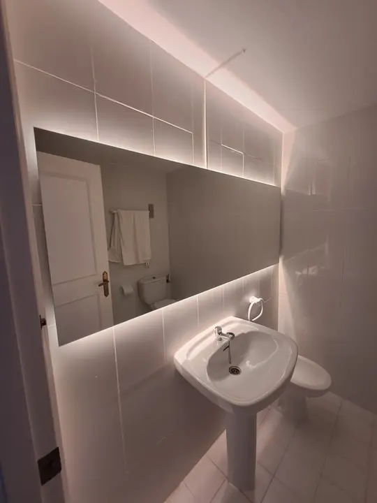 Large backlit mirror in a cloakroom
