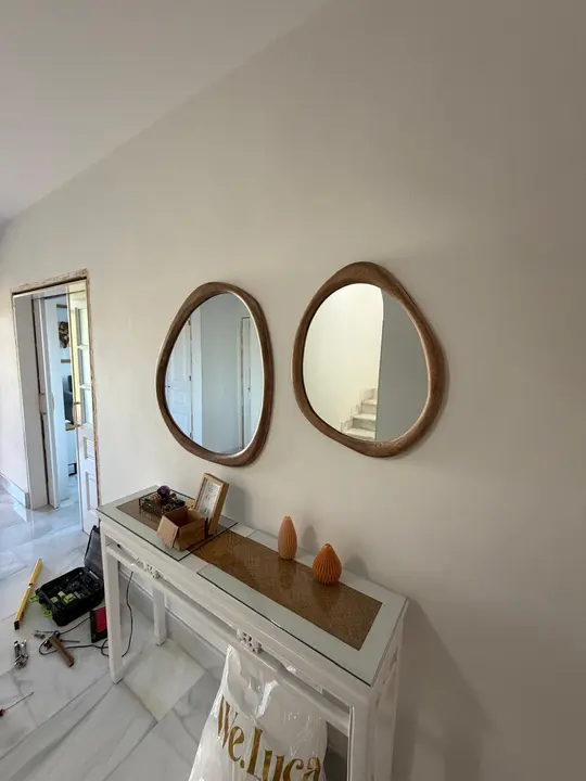 Organic-shaped wooden-framed mirrors in an entrance hall