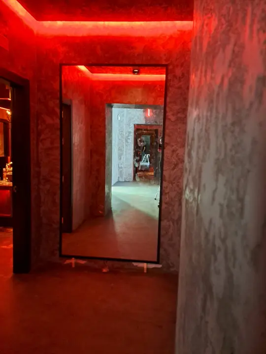 Mirror with a red LED profile in a hospitality hallway