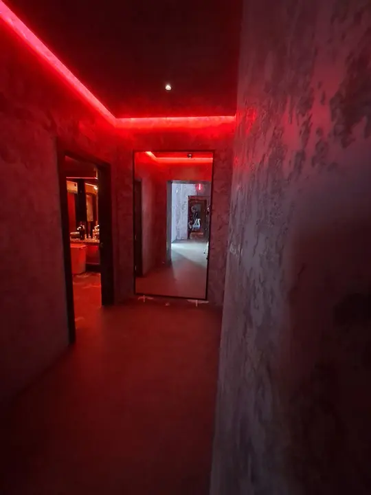 Hallway with a full-length mirror and red LED lighting