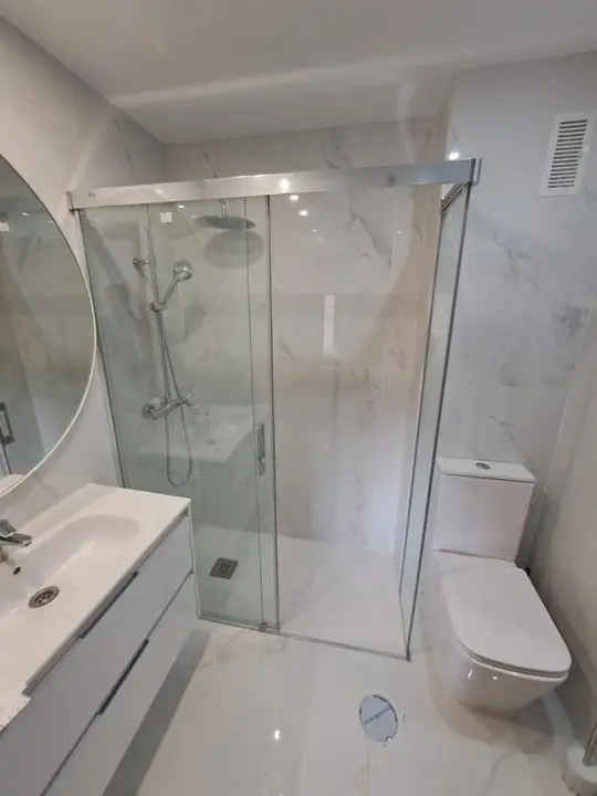 Clear sliding glass shower screen in a marble bathroom