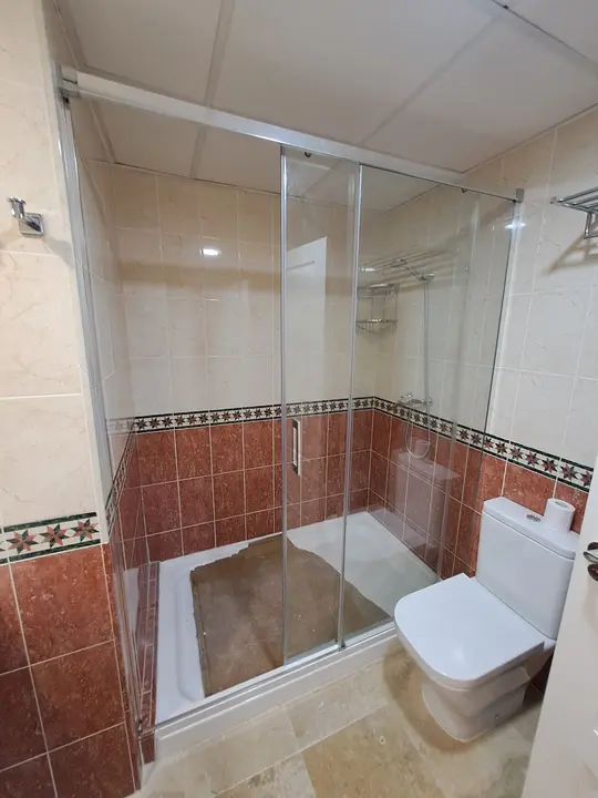 Sliding shower screen over a shower tray