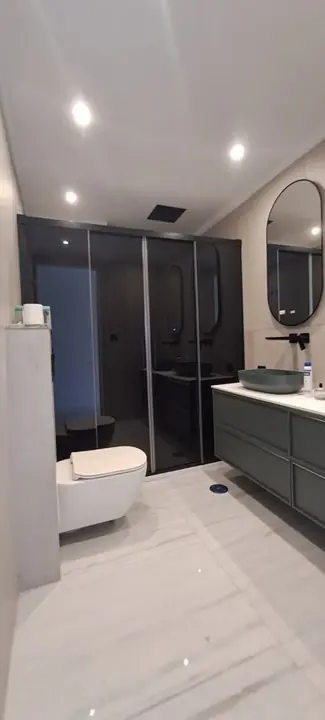 Shower screen in a modern bathroom with a round mirror
