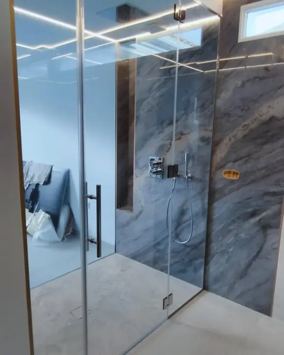 Toughened glass shower screen in a grey marble bathroom