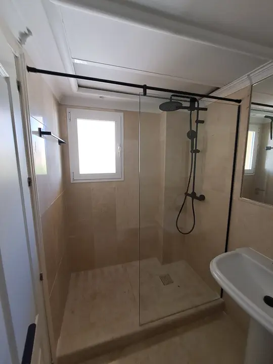 Shower screen with a black profile in a tiled walk-in shower