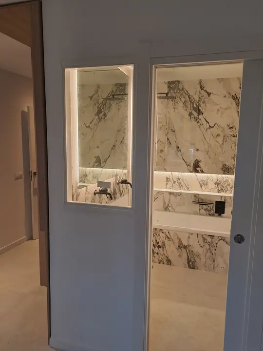 Interior glass window onto a marble bathroom