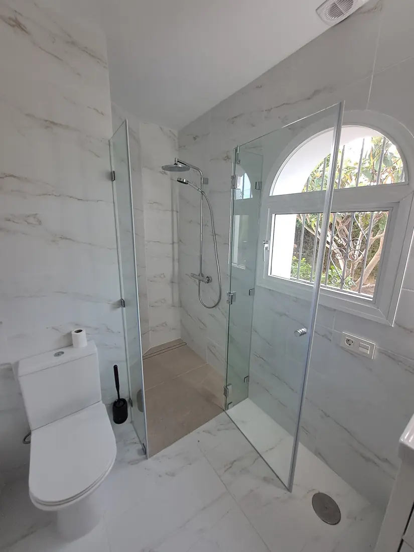 Mampara de baño de cristal a medida instalada en Marbella